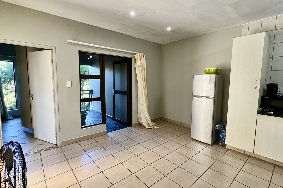 Open plan living and kitchen area featuring tiled flooring, recessed lighting, and direct access to an outdoor balcony space.