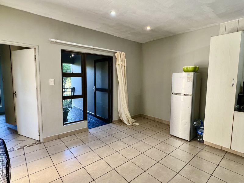 Open plan living and kitchen area featuring tiled flooring, recessed lighting, and direct access to an outdoor balcony space.
