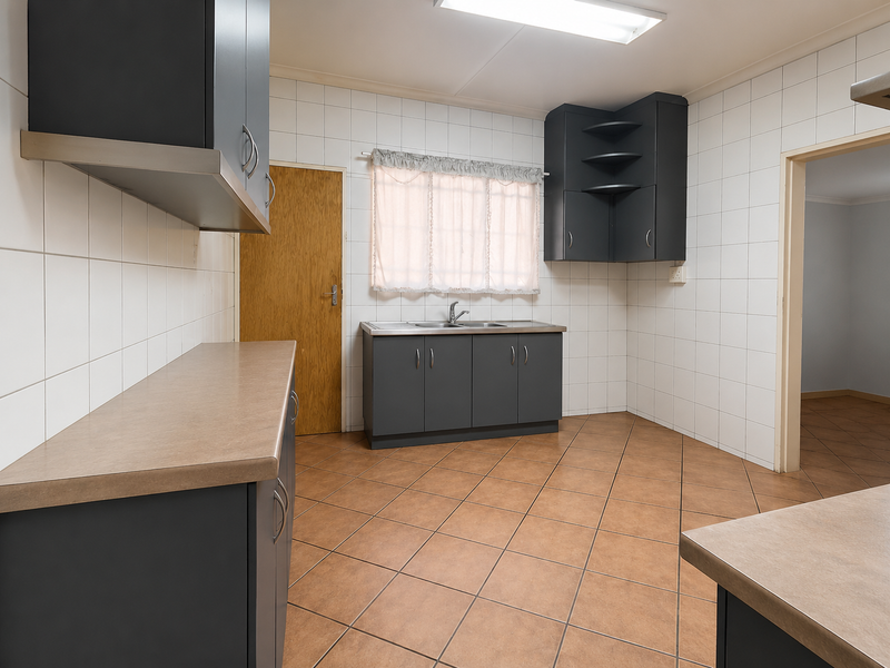 A functional kitchen featuring dark grey cabinetry, laminate countertops, tiled splashbacks, and ceramic floor tiles, offering a clean and practical workspace.