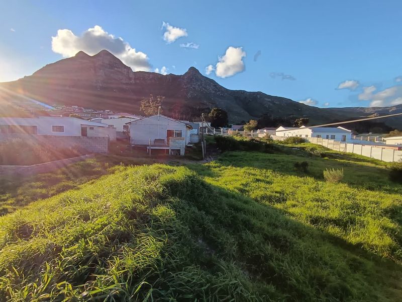 A scenic view of the surrounding landscape featuring open grassland and a prominent mountain backdrop.