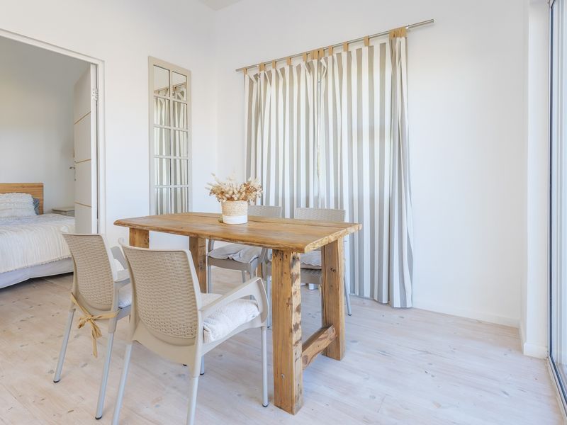 Bright dining area featuring light-toned laminate flooring and a large sliding glass door providing access to the outdoor space.