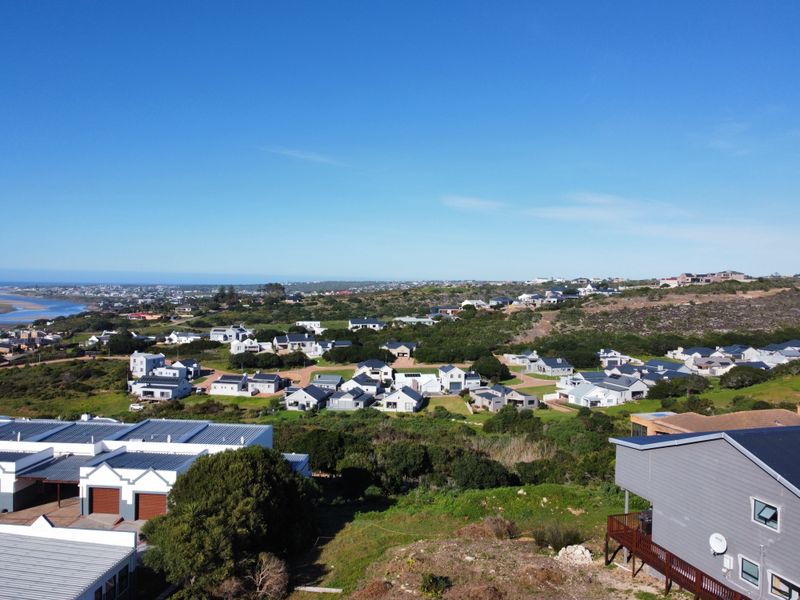 An aerial view of the residential estate, showcasing the surrounding landscape, coastal proximity, and established neighborhood layout.
