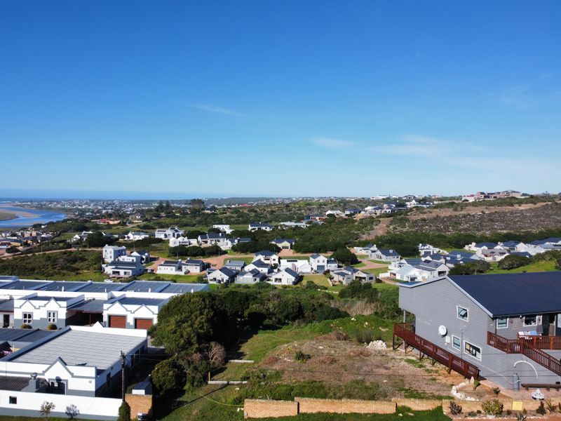 An aerial view of the residential estate and surrounding coastal landscape, showcasing the property's location within the neighborhood.