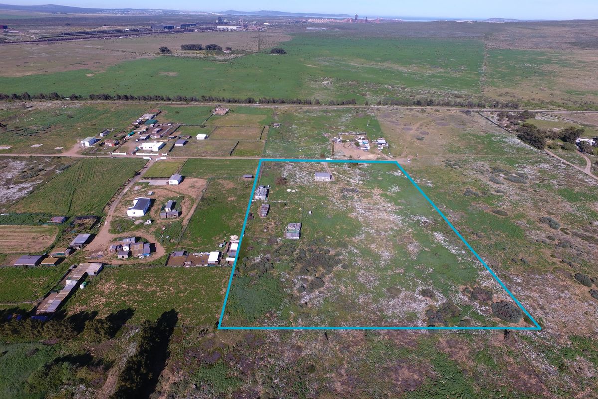 Aerial view of a large, undeveloped small holding plot with a defined perimeter, situated in a rural landscape.