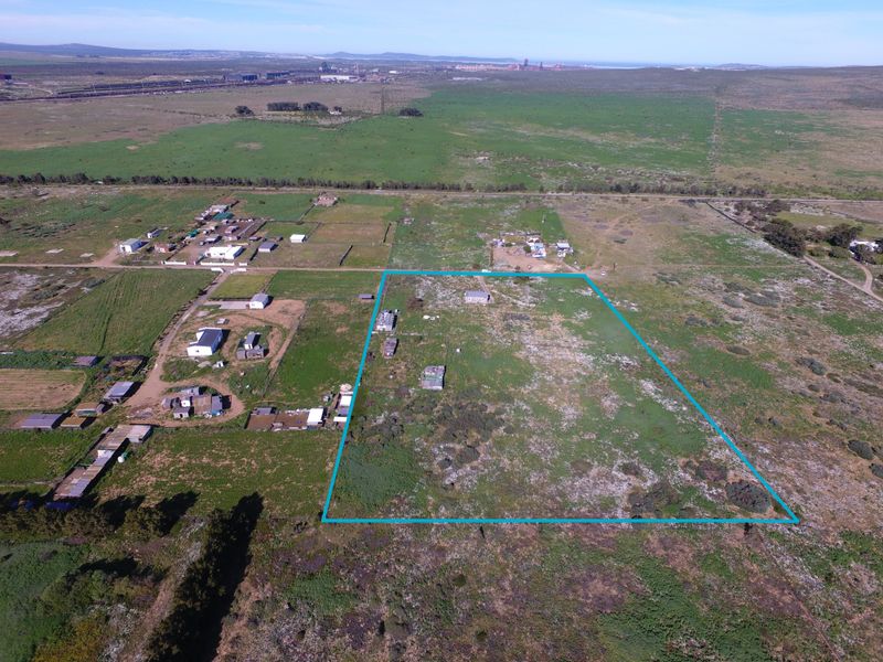 Aerial view of a large, undeveloped small holding plot with a defined perimeter, situated in a rural landscape.