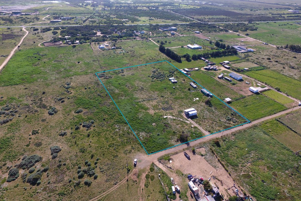 Aerial view of a large, undeveloped small holding plot with perimeter fencing and surrounding rural landscape.