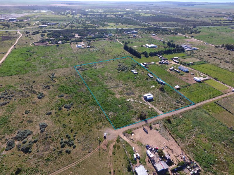 Aerial view of a large, undeveloped small holding plot with perimeter fencing and surrounding rural landscape.