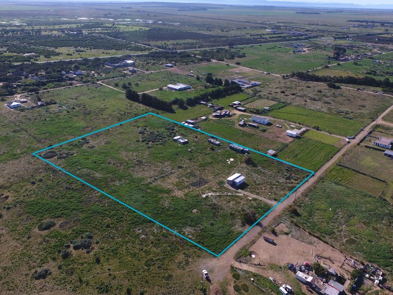 Aerial view of a large, undeveloped small holding plot with clear boundary markings, situated in a rural landscape.