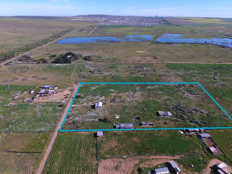 Aerial view of a large rural small holding property featuring multiple outbuildings and expansive open land with a clearly marked boundary.