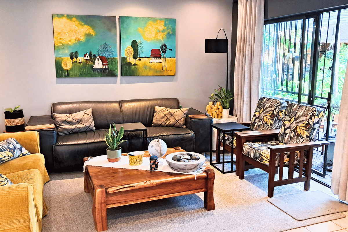A comfortable living room featuring large sliding glass doors with security gates, providing natural light and access to the outdoor area.
