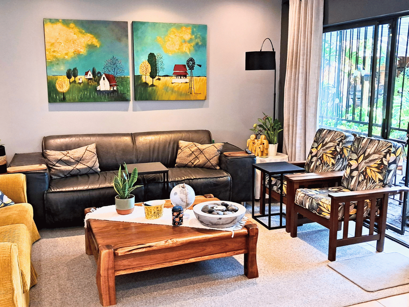A comfortable living room featuring large sliding glass doors with security gates, providing natural light and access to the outdoor area.