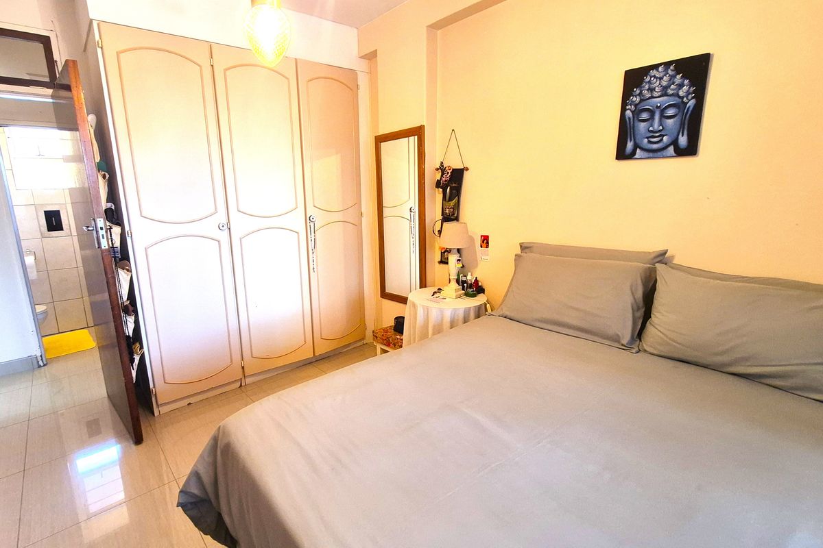 A bedroom featuring built-in wardrobes, tiled flooring, and direct access to an en-suite bathroom.
