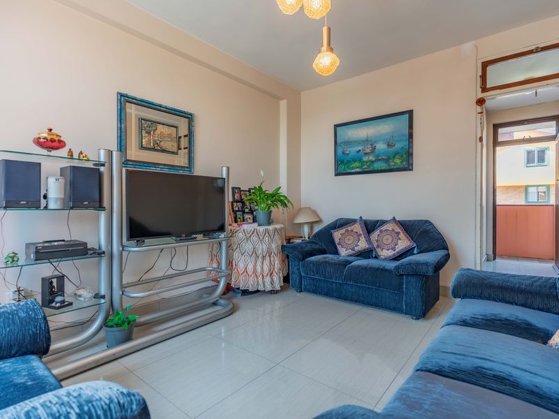 A comfortable living room featuring tiled flooring and direct access to an outdoor balcony area.