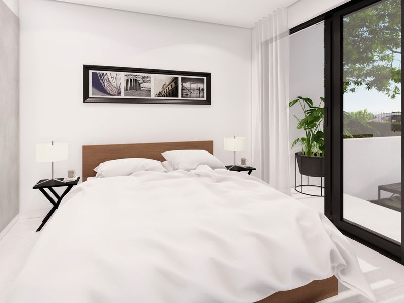 Modern bedroom featuring built-in shelving, sleek tiled flooring, and large sliding glass doors providing access to an outdoor area.