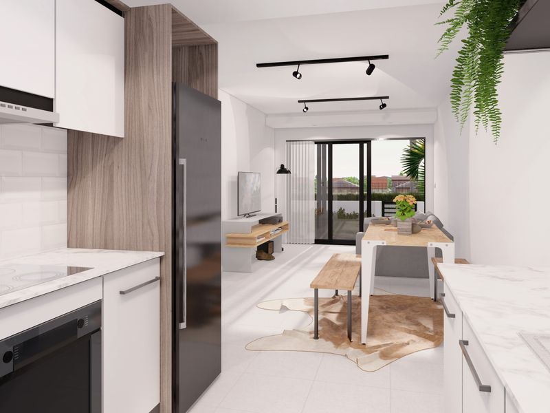 Modern open-plan kitchen and living area featuring contemporary cabinetry, integrated appliances, track lighting, and seamless access to an outdoor balcony.