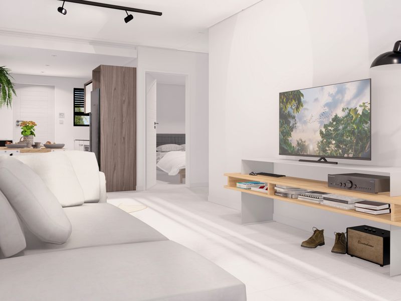 Modern open-plan living area featuring track lighting, neutral finishes, and a seamless transition to the kitchen and bedroom spaces.