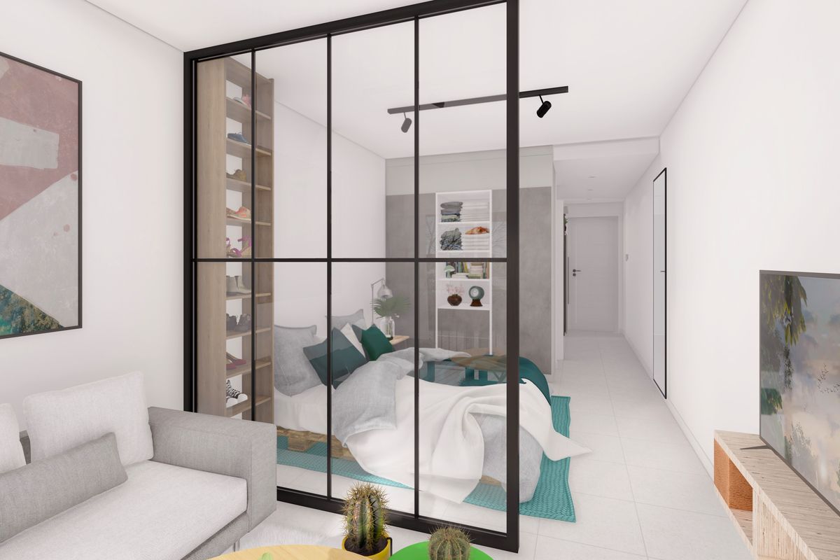 Modern open-plan apartment interior featuring a sleek black metal and glass partition separating the living area from the bedroom space.