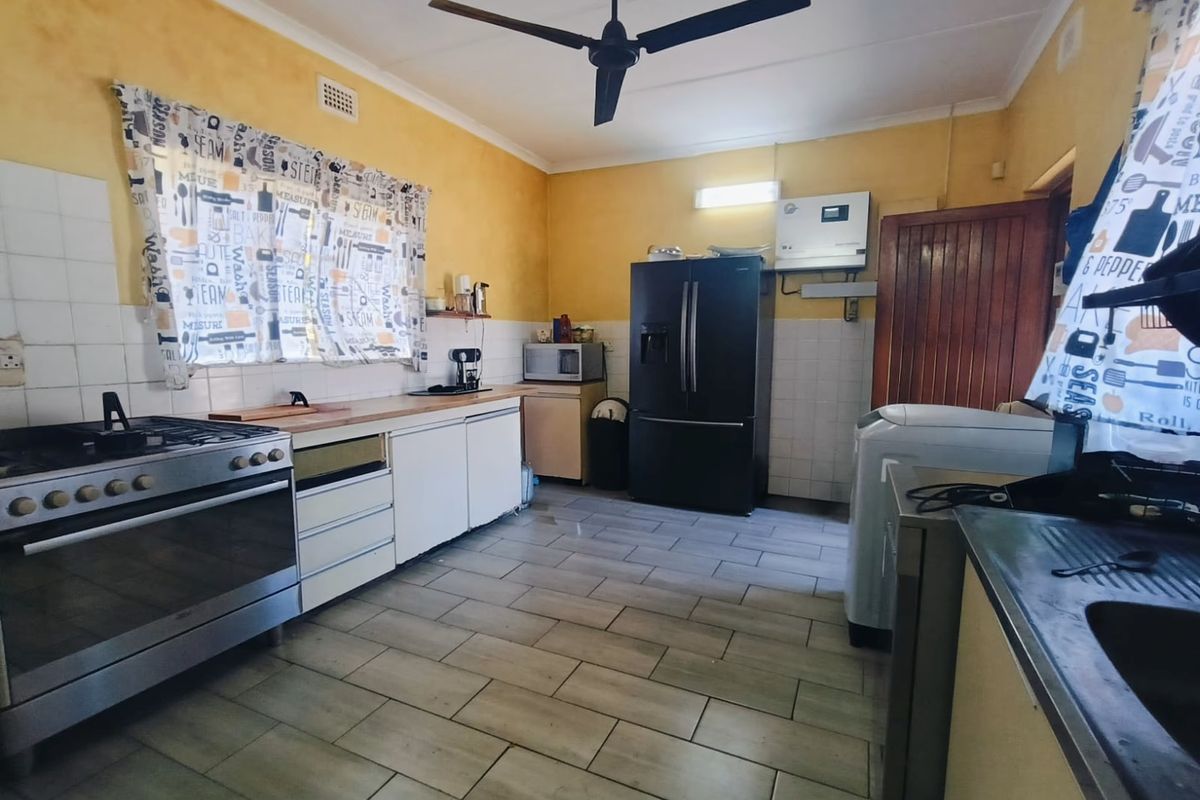 A functional kitchen featuring tiled flooring, a gas stove with oven, and an integrated inverter system, offering a practical layout for daily meal preparation.
