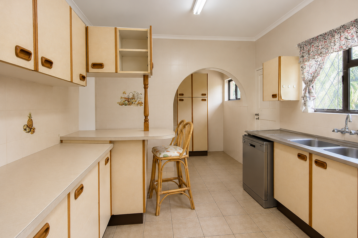 A functional kitchen featuring laminate cabinetry, tiled surfaces, and a double bowl sink, offering a classic layout with potential for modern updates.