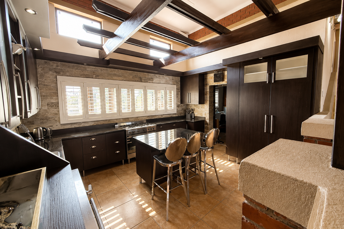 Modern kitchen featuring dark cabinetry, a central island, exposed timber beams, and stone tile accents, creating a warm and functional culinary space.