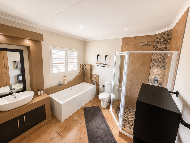 A well-maintained bathroom featuring a built-in vanity with vessel sink, a separate bathtub, and a glass-enclosed shower with mosaic tile accents.