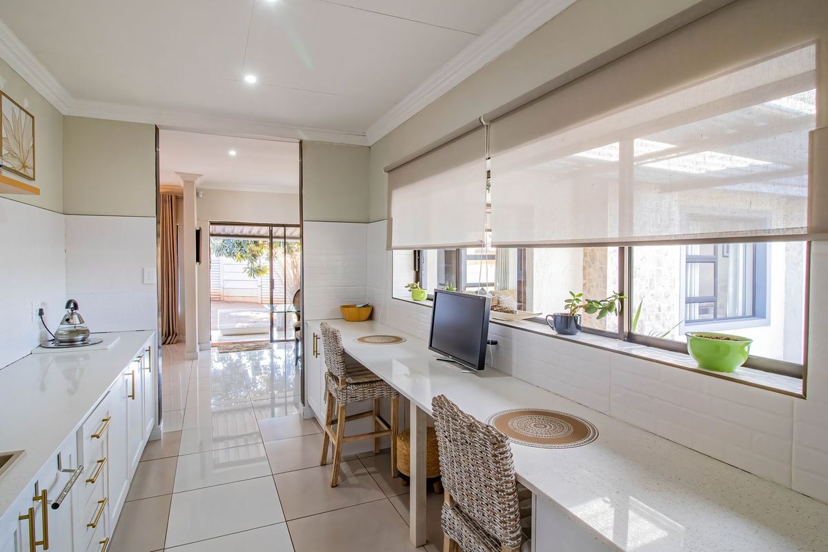 Modern kitchen featuring sleek quartz countertops, subway tile backsplash, and a built-in breakfast bar with ample natural light.