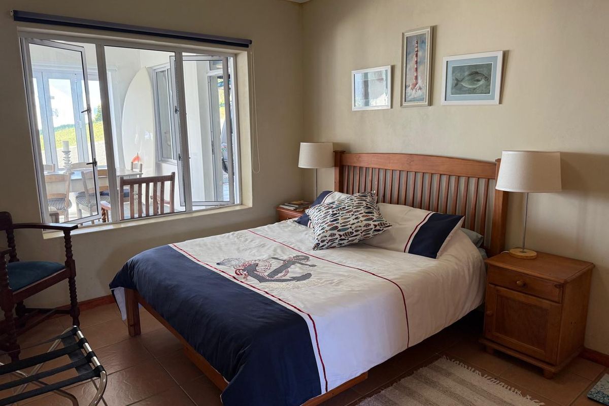 A bedroom featuring tiled flooring and a large window with views into an adjacent patio area.