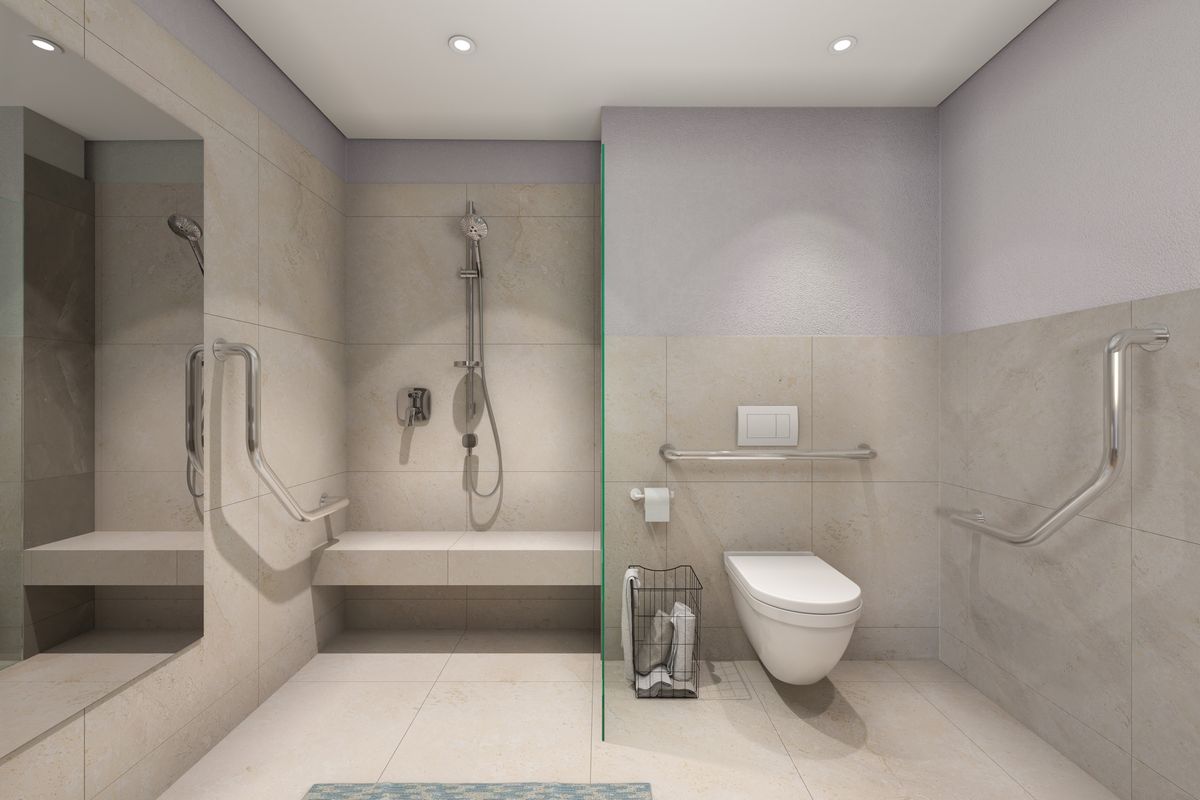 Modern accessible bathroom featuring a walk-in shower with built-in bench, wall-mounted toilet, and safety grab rails, finished with neutral floor-to-ceiling tiling.