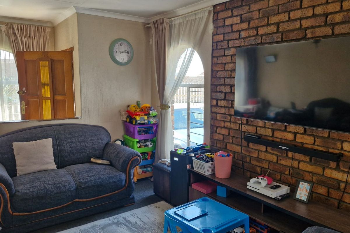 A living room featuring an exposed brick feature wall and arched windows, providing a characterful foundation for modern interior updates.