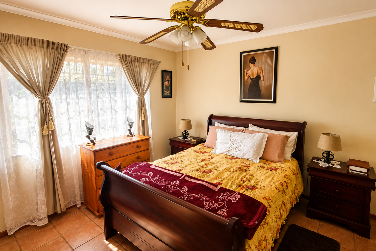 A well-maintained bedroom featuring tiled flooring, a central ceiling fan, and neutral wall tones, offering a comfortable and functional living space.