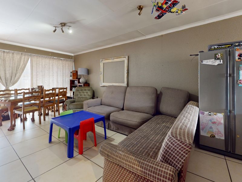 Open-plan living and dining area featuring tiled flooring and access to the exterior via a sliding glass door.