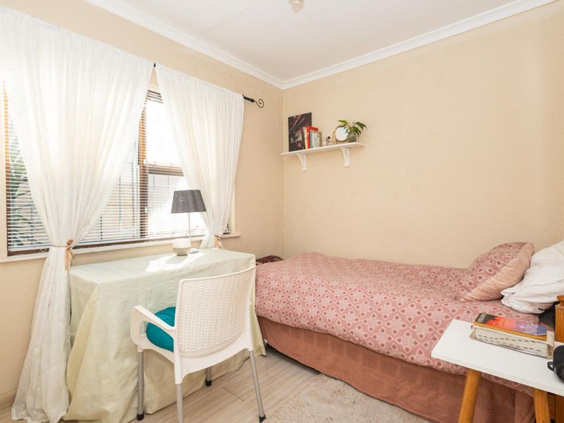 A compact bedroom featuring neutral walls, coving, and a window with natural light.