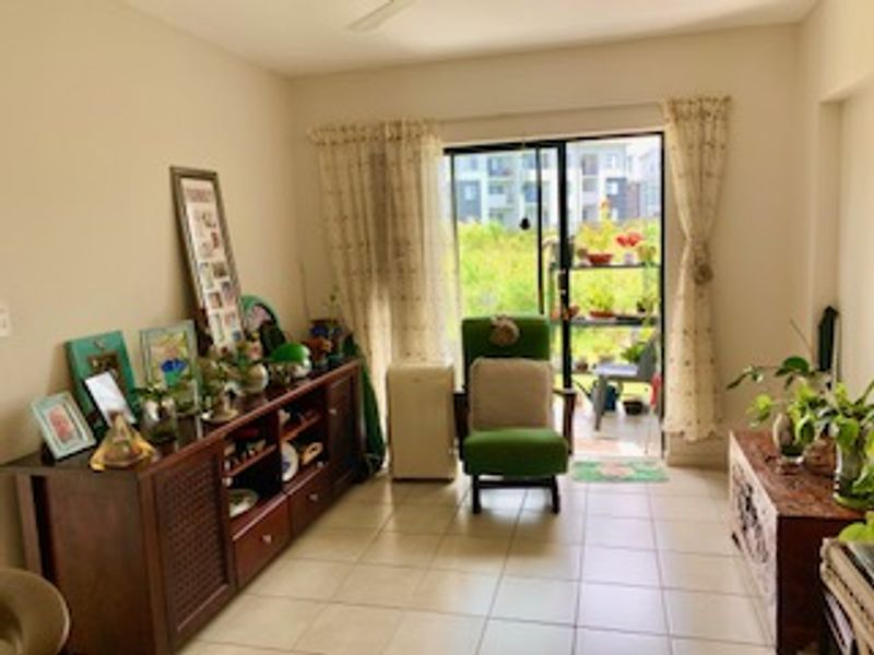 A living room featuring ceramic tile flooring and a sliding glass door providing access to an outdoor balcony area.