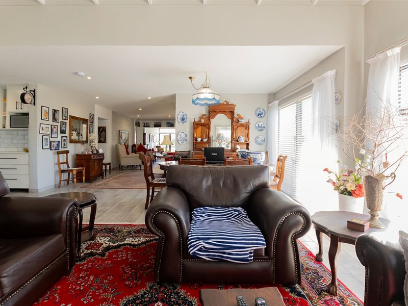 Spacious open-plan living and dining area featuring tiled flooring, recessed lighting, and an integrated kitchen with a classic subway tile backsplash.