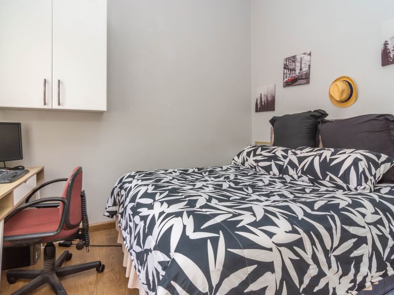 A functional bedroom featuring laminate flooring and convenient built-in wall cabinetry for storage.