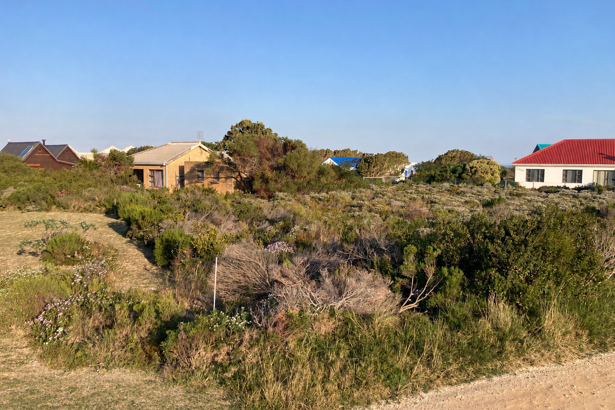 A view of a vacant residential plot covered in indigenous vegetation, situated in a developed neighborhood.
