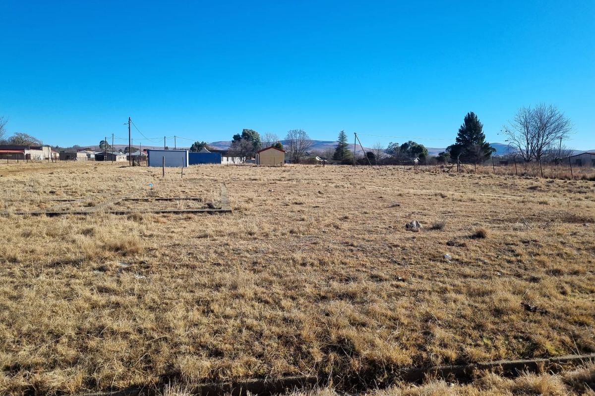 A vacant residential plot featuring a concrete foundation slab and perimeter fencing, offering a clear space for future development.