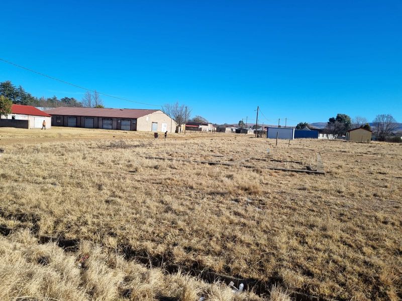 A vacant residential plot featuring a concrete foundation slab, situated in an established neighborhood with surrounding infrastructure.