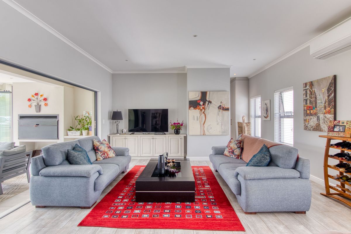 Spacious living room featuring tiled flooring, built-in cabinetry, recessed lighting, and large sliding doors providing seamless access to the outdoor patio area.