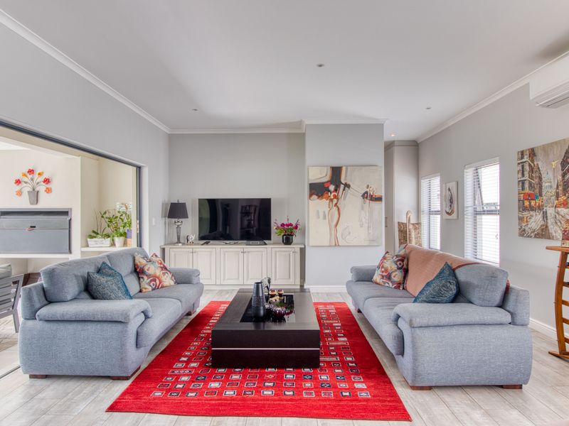 Spacious living room featuring tiled flooring, built-in cabinetry, recessed lighting, and large sliding doors providing seamless access to the outdoor patio area.