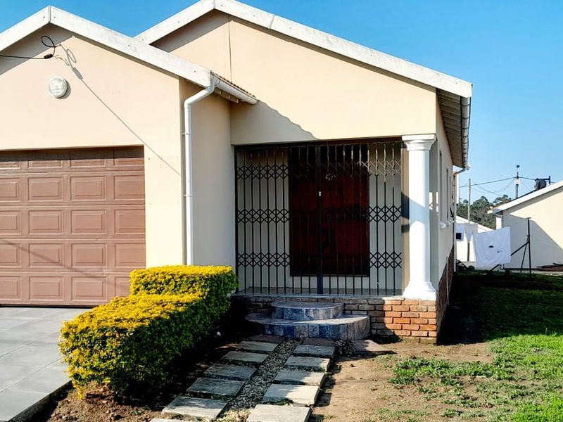 Front elevation of a single-story house featuring a garage, tiled entrance steps with a security gate, and a paved walkway.