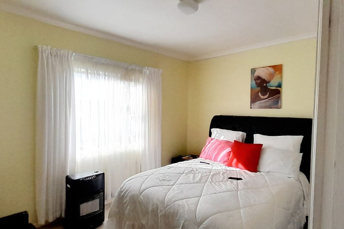 A standard bedroom featuring a window with curtains and neutral wall finishes, providing a comfortable and functional sleeping space.