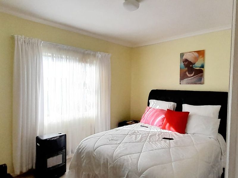 A standard bedroom featuring a window with curtains and neutral wall finishes, providing a comfortable and functional sleeping space.