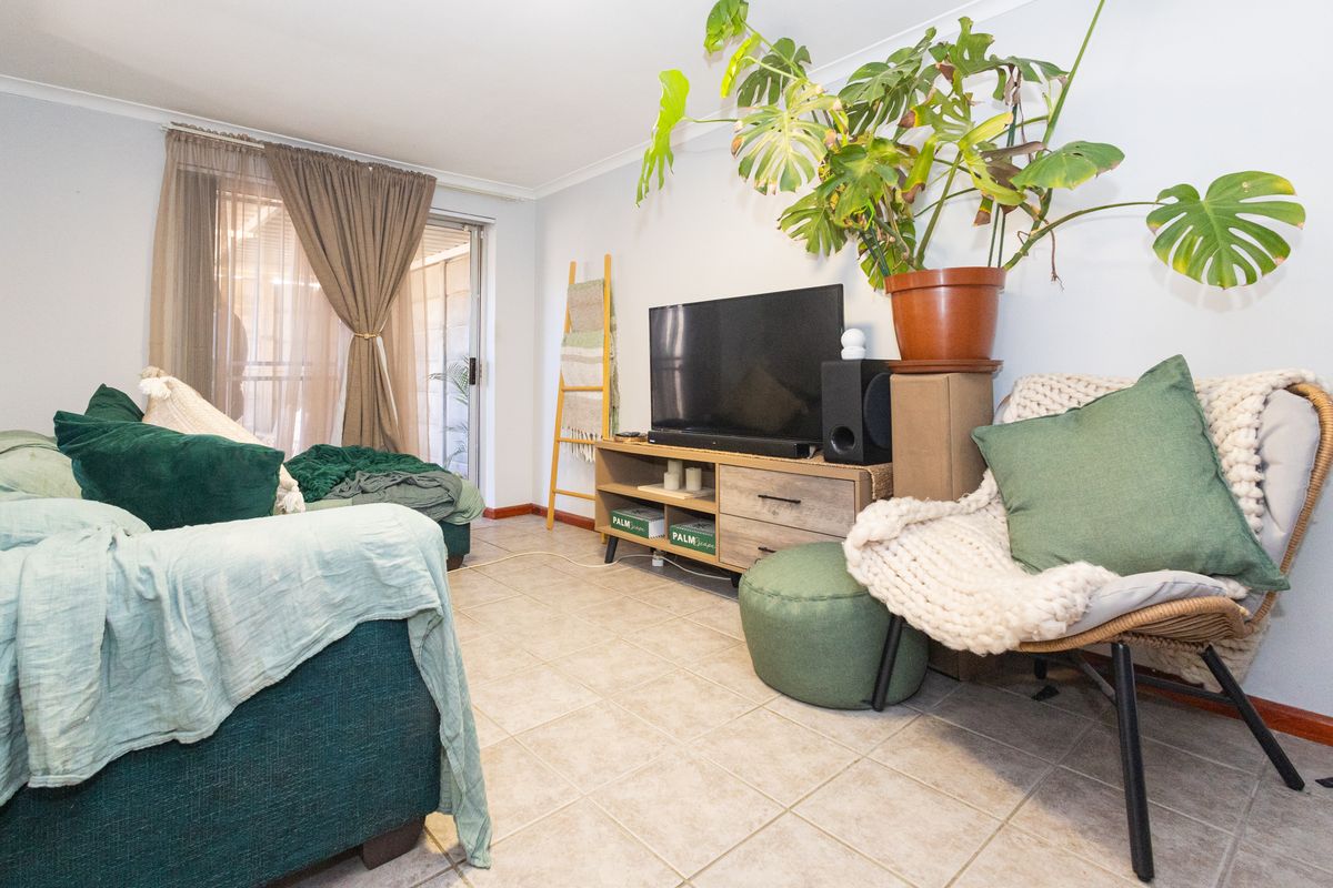 A living room featuring tiled flooring and a sliding glass door providing access to the exterior.