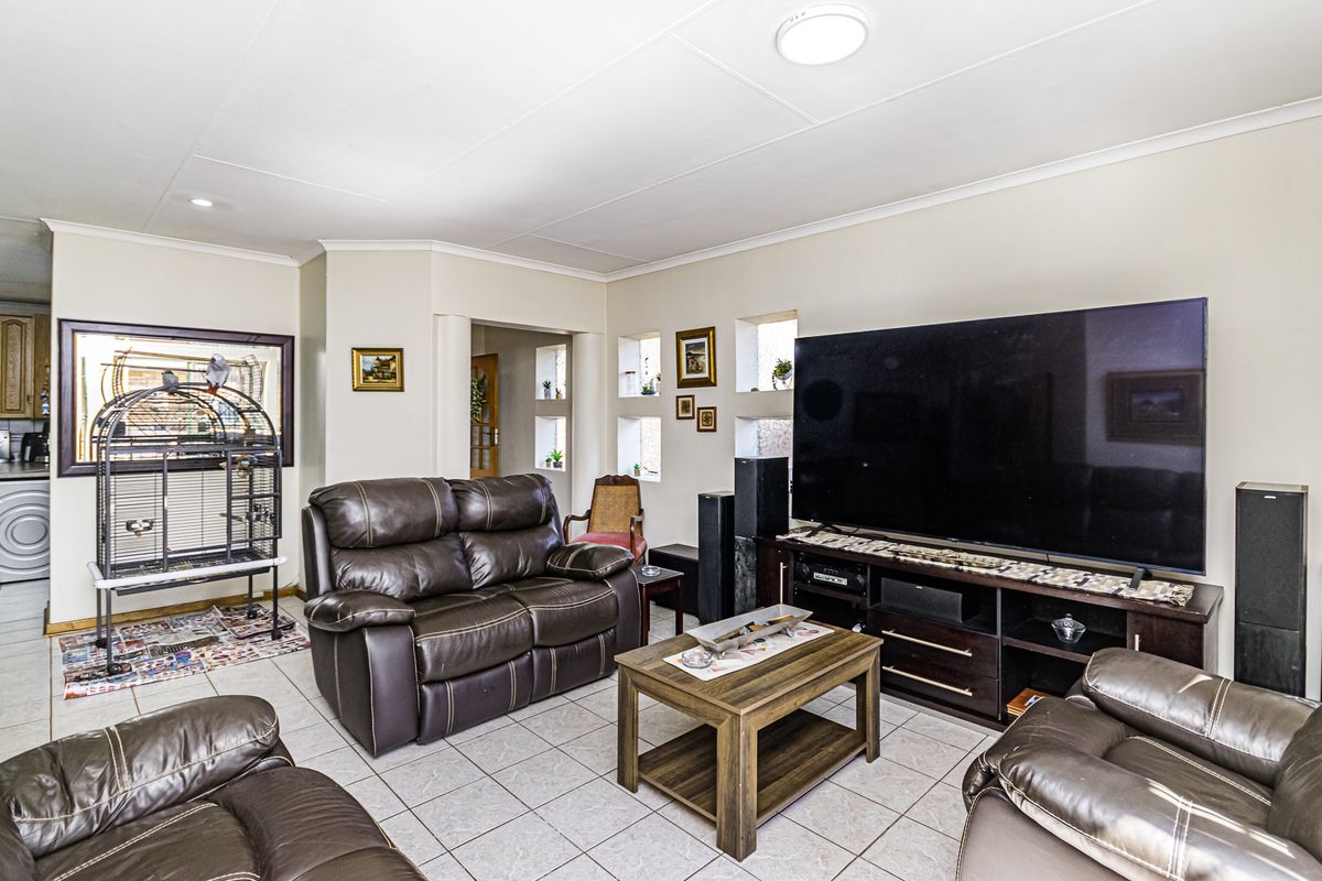 A spacious living room featuring tiled flooring, coved ceilings, and unique recessed wall niches, providing a functional and comfortable living space.