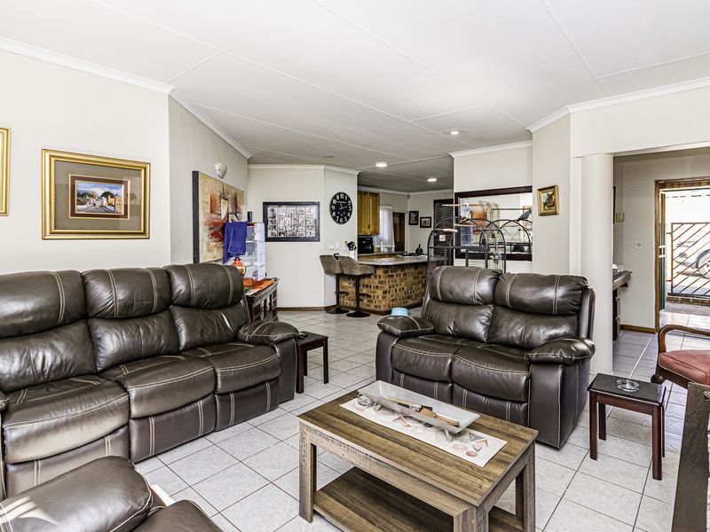 Open-plan living area featuring tiled flooring, a brick breakfast bar, and direct access to the entrance.