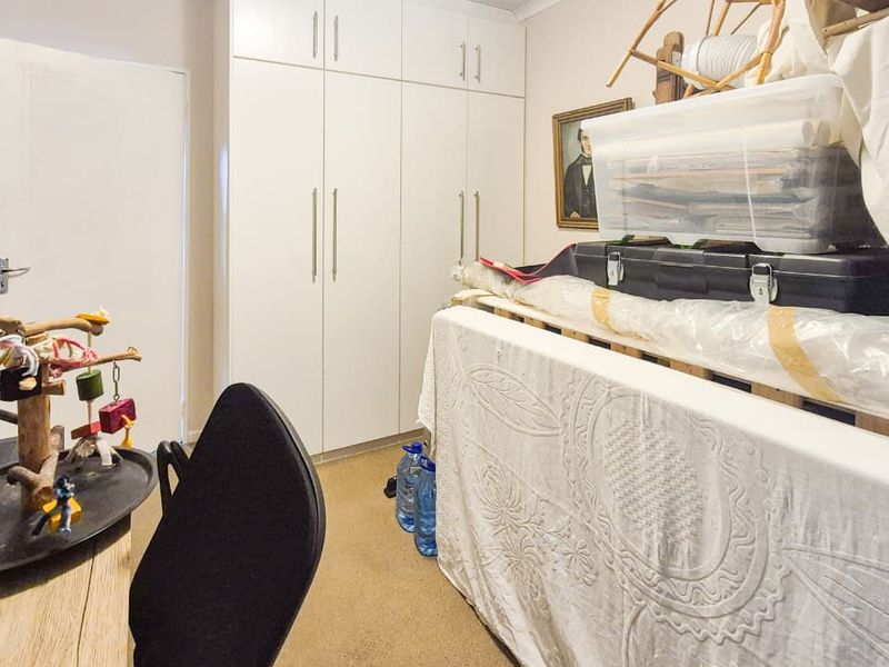Bedroom featuring floor-to-ceiling built-in cupboards and neutral carpeting.