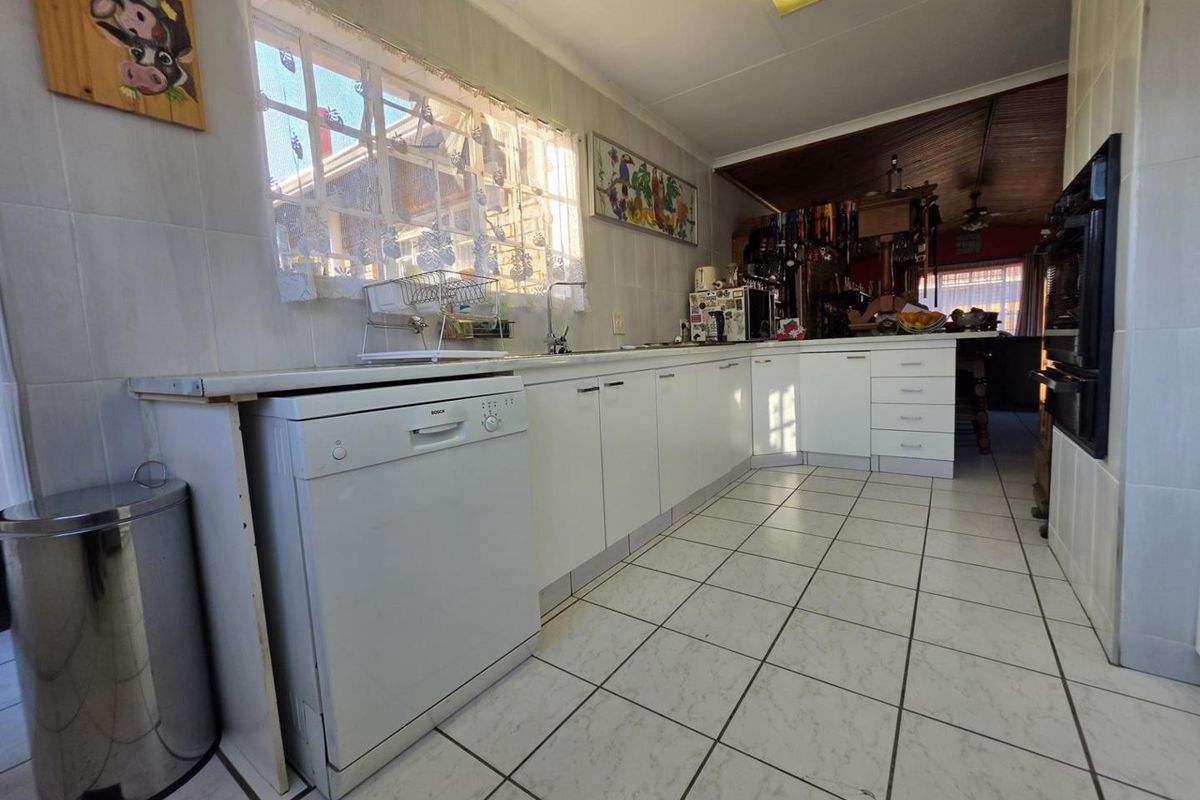 A functional kitchen featuring white cabinetry, tiled surfaces, and a built-in oven, offering a clean layout with potential for modern updates.