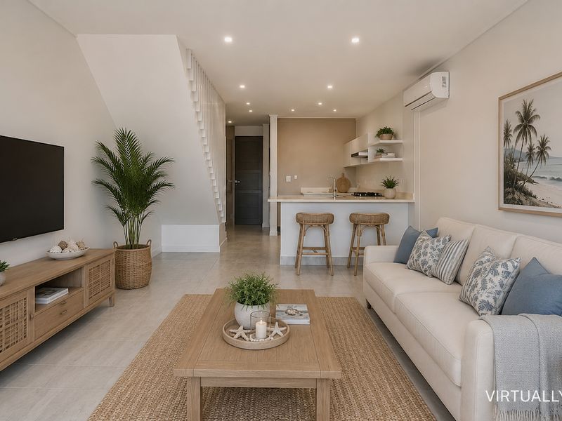 Modern open-plan living area featuring a sleek kitchen island, recessed lighting, split-system air conditioning, and a staircase, finished with neutral tiled flooring.