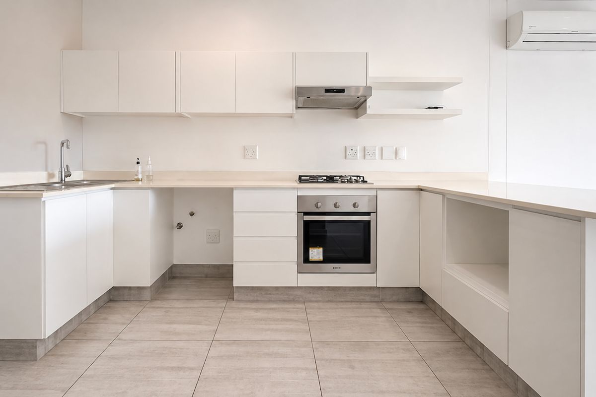 Modern, minimalist kitchen featuring white cabinetry, stone countertops, integrated stainless steel oven, gas hob, extractor fan, and tiled flooring.